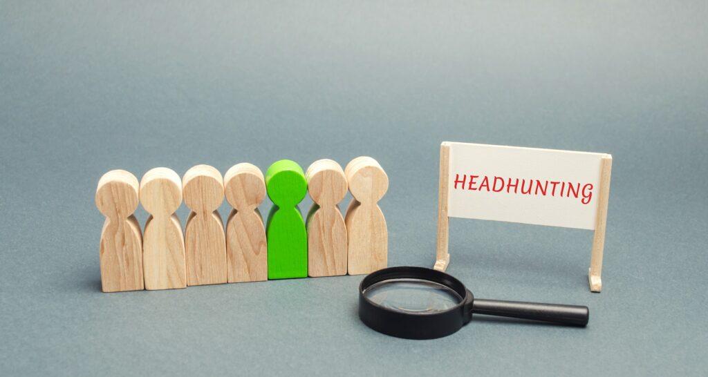 A poster with the word Headhunting, a crowd of people and a magnifying glass