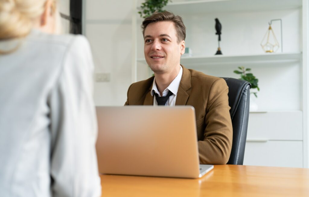 Businessman using laptop asking candidate new employee businesswoman during interview at office